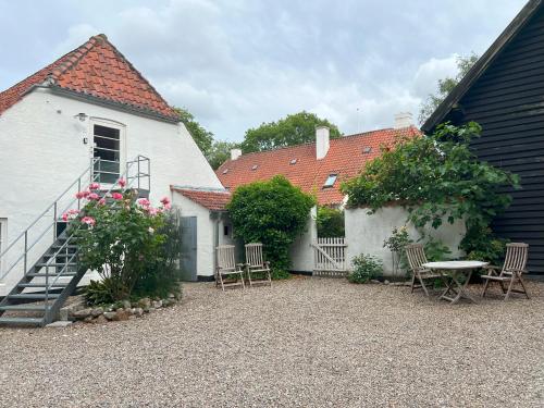 a courtyard with chairs and a table and a building at Skovridergaardens Ferielejligheder in Aabenraa