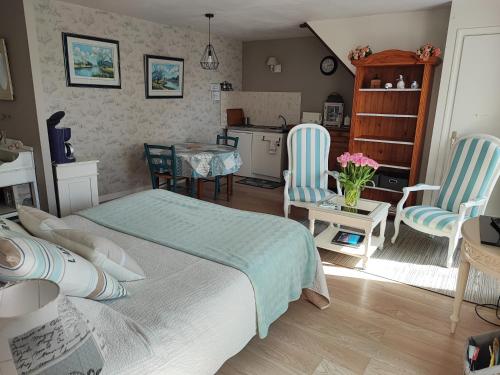 une chambre avec un lit, une table et des chaises dans l'établissement Les Hortensias de Kerbarch, à Ploemel