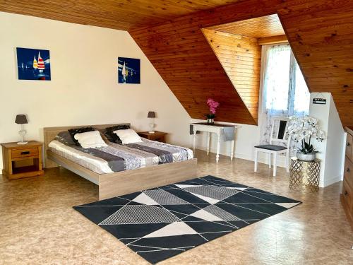 une chambre avec un lit et un plafond en bois dans l'établissement Appartement deux chambres plus une chambre bébé ou enfant maximum trois ans à la campagne au calme, à Cléguérec