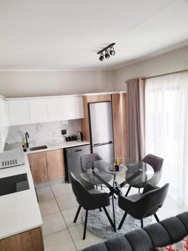 a kitchen and dining room with a table and chairs at The Blyde Crystal Lagoon Penthouse in Avondzon