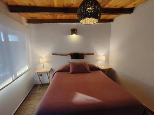 una camera da letto con un grande letto con due comodini di Hostal Lackuntur a San Pedro de Atacama