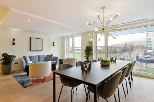 uma sala de jantar e sala de estar com mesa e cadeiras em The Oslo One by Dublin At Home em Galloping Green