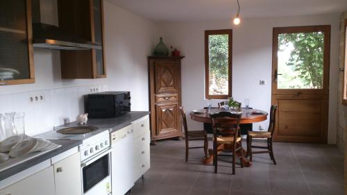 une cuisine avec une table et une petite table avec des chaises dans l'établissement Gîtes dans village médiéval Périgord, à Limeuil