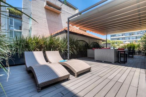 a patio with two chairs and an umbrella at AR 218 Hotel by ULIV in Mexico City