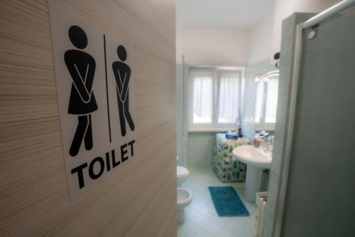 a bathroom with a toilet and a sign on the door at Bragadin75 In Vaticano in Rome