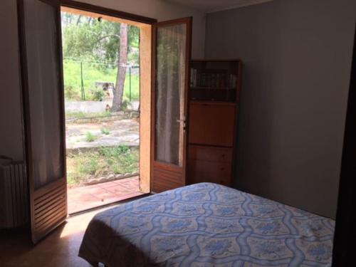 ein Schlafzimmer mit einem Bett und einer Glasschiebetür in der Unterkunft Marseille - Calanques in Marseille