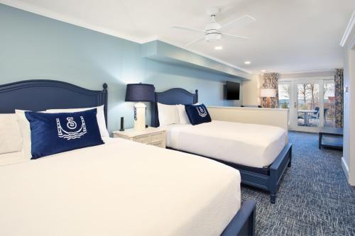 two beds in a room with blue walls at The Inn at Stonecliffe in Mackinac Island