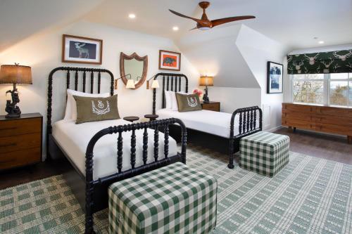 a bedroom with two beds and a ceiling fan at The Inn at Stonecliffe in Mackinac Island