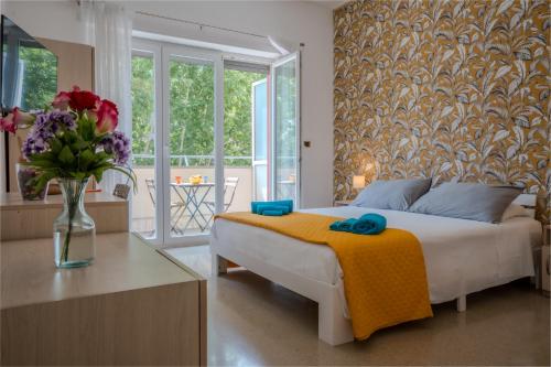 a bedroom with a bed with a vase of flowers at Bragadin75 In Vaticano in Rome