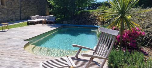 una silla sentada junto a una pequeña piscina en Clos Baroanni - Chambre Oléa, en Terraube