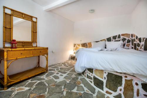 a bedroom with a bed with a mirror and a dresser at Mountain Stone Rooms in Mariaí