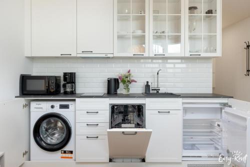 a kitchen with a washing machine and a microwave at Apartamenty Pinea z widokiem na morze Easy - Rent Apartments in Pobierowo