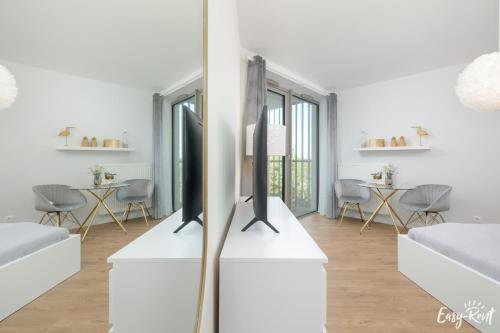 a living room with two monitors on a white table at Apartamenty Pinea z widokiem na morze Easy - Rent Apartments in Pobierowo