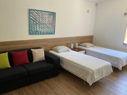 a room with two beds and a couch at Cantinho do Carmo in Fragoso