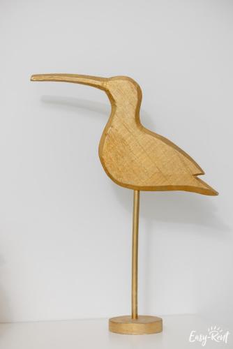 a wooden bird on a stand on a white background at Apartamenty Pinea z widokiem na morze Easy - Rent Apartments in Pobierowo