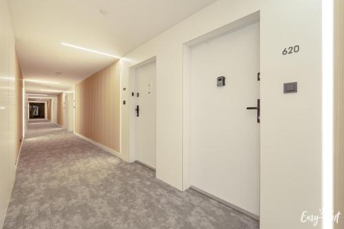 an empty hallway with white walls and doors at Apartamenty Pinea z widokiem na morze Easy - Rent Apartments in Pobierowo