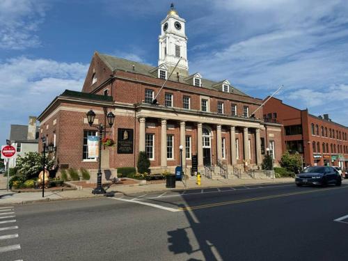 a large brick building with a clock tower on top of it at Upscale Industrial Penthouse in Plymouth