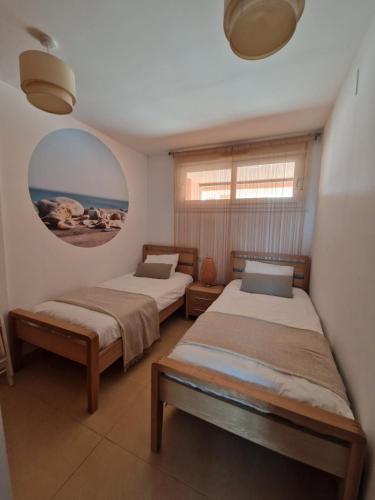 a bedroom with two beds and a window and a mirror at Casa Bella Vista in Alhama de Murcia