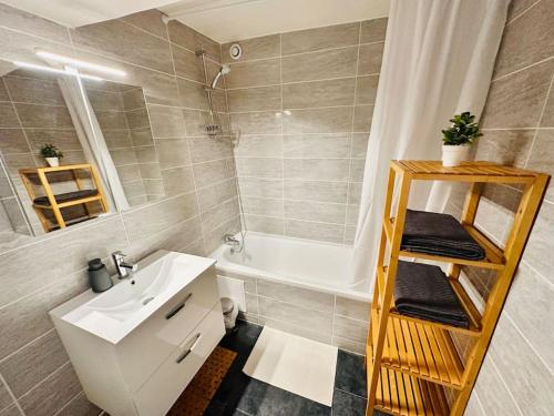 une salle de bain avec un lavabo, une baignoire et des toilettes dans l'établissement Cosy Saint-Denis 2 personnes, à Saint-Denis
