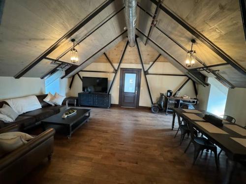 a large living room with a couch and a table at Upscale Industrial Penthouse in Plymouth