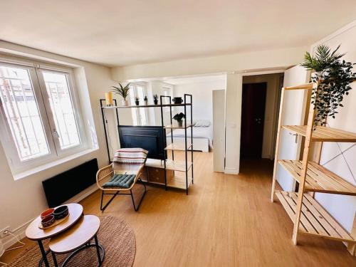 un salon avec un canapé, une table et une télévision dans l'établissement Cosy Saint-Denis 2 personnes, à Saint-Denis