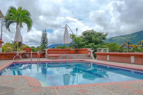a swimming pool in a resort with mountains in the background at Cabaña campestre en Tuluá in Tuluá