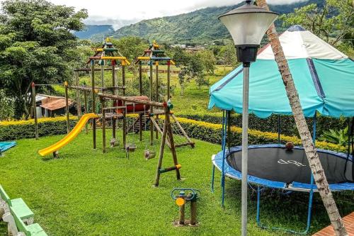 a park with a playground with slides and swings at Cabaña campestre en Tuluá in Tuluá