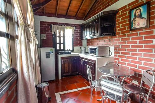 a small kitchen with a table and a brick wall at Cabaña campestre en Tuluá in Tuluá