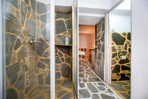 a bathroom with a shower with a stone wall at Mountain Villa in Maries