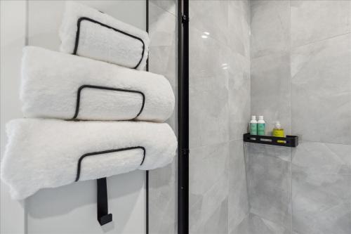 a pile of towels sitting on a towel rack in a bathroom at The Oak Hotel in Nelson