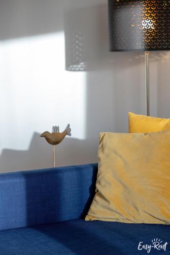 a blue couch with a bird on top of it at Apartamenty Pinea z widokiem na morze Easy - Rent Apartments in Pobierowo