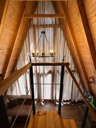 a chandelier in a attic with a large window at Oasis of peace in Šavnik