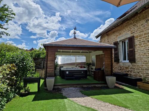 a gazebo with a grill in a yard at Chambres d'hôtes Une autre maison in Pupillin