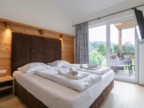 a bedroom with a large bed with a large window at Apart33 Top 2-15 in Haus im Ennstal