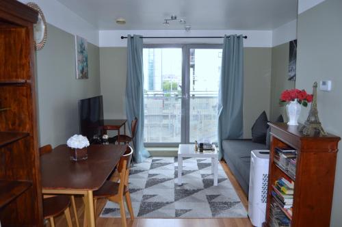 a living room with a couch and a table at Entire Apartment next to Canary Wharf in London in London