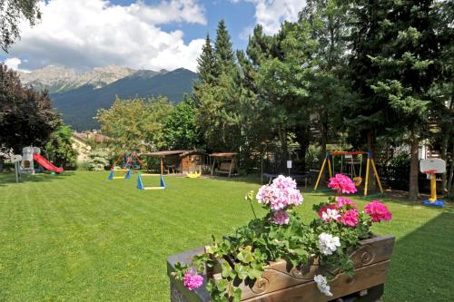 a park with a playground with flowers and swings at Residence Lastè in Moena