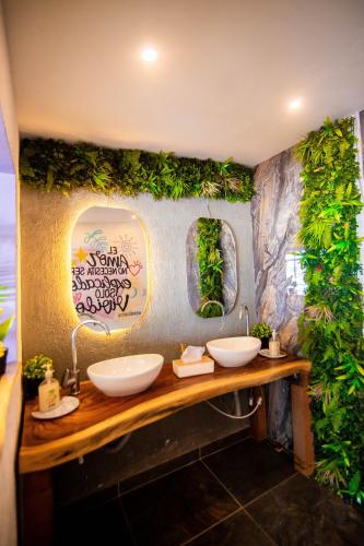 a bathroom with two sinks and plants on the wall at Hotel Marie Real Cartagena in Cartagena de Indias