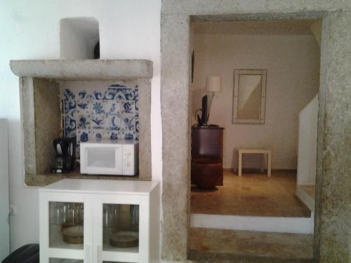 a view of a living room with a microwave at Typical small house near Lisbon in Oeiras