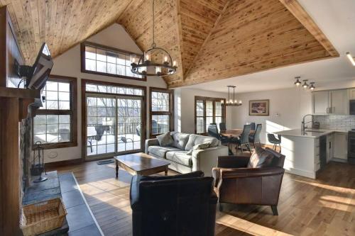 a living room with a couch and a table at Les Falaises Mont Tremblant Luxury Ski Retreat in Mont-Tremblant
