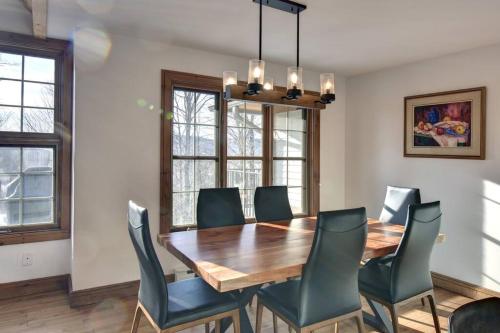 a dining room with a wooden table and chairs at Les Falaises Mont Tremblant Luxury Ski Retreat in Mont-Tremblant