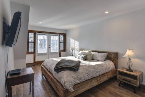 a bedroom with a large bed and a television at Les Falaises Mont Tremblant Luxury Ski Retreat in Mont-Tremblant