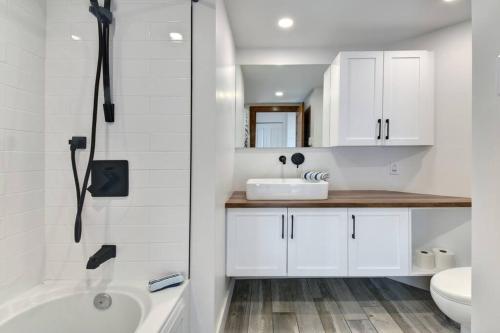 a white bathroom with a tub and a sink at Les Falaises Mont Tremblant Luxury Ski Retreat in Mont-Tremblant