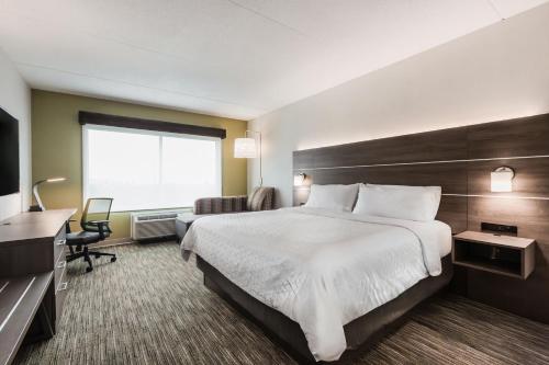 a hotel room with a large bed and a window at Holiday Inn Express & Suites - Welland in Welland