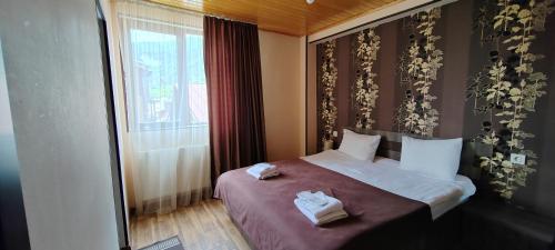 a bedroom with a bed with two towels on it at Hotel Svanseti in Mestia