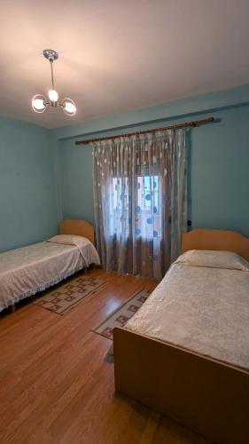 a room with two beds and a window at visitShkoder - Noel's Home in Shkodër
