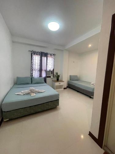 a bedroom with two beds and a window at DonRio Hotel Siquijor in Siquijor