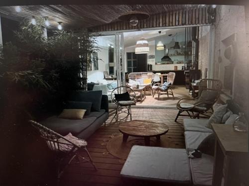 d'une terrasse avec un canapé, des chaises et une table. dans l'établissement Charmante maison de vacances, à Saint-Michel-Chef-Chef