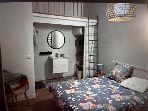 une chambre avec un lit, un miroir et un lavabo dans l'établissement Charmante maison de vacances, à Saint-Michel-Chef-Chef