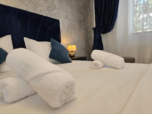 ブカレストにある89 Rooms Boutiqueの白いシーツと枕が付いたベッドが2つある寝室