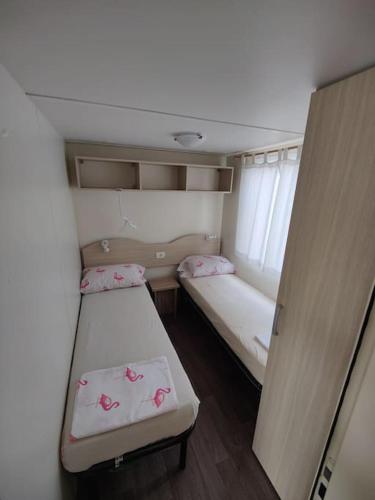 a small room with two beds and a window at Apartma Valce in Zgornje Škofije